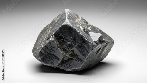 Close up of a rough unpolished diamond crystal on a light gray background
