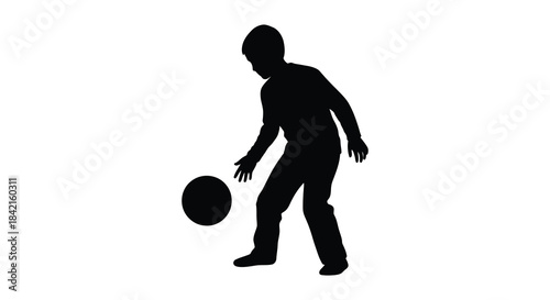 A young boy playing with a ball captured in a striking black and white silhouette