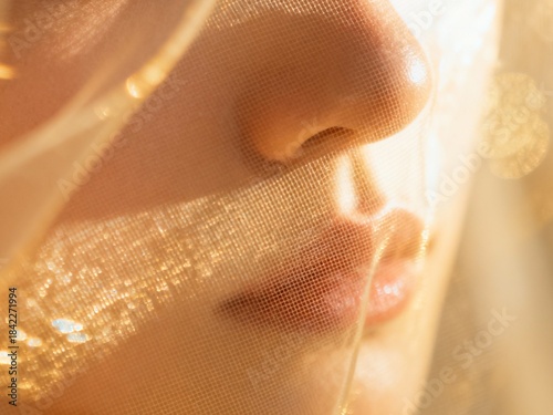 女性の口元と輝くベール