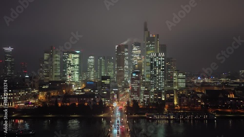 Wallpaper Mural Aerial view of illuminated Frankfurt am Main skyline at night. Financial district's skyscrapers reflect on the Main river while traffic flows over water Torontodigital.ca