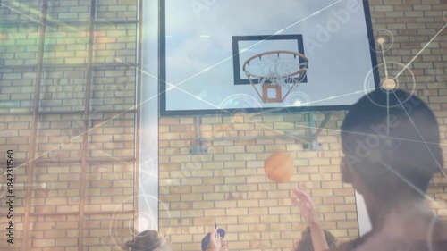 Team practicing under hoop, shooter releasing ball, coach catching while overlay guiding education