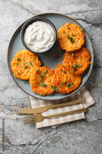 Sweet Potato hash browns, a cooked vegetable breakfast food closeup on the plate on the table. Vertical top view from above