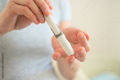 Close-up of pregnant female using glucometer to measure blood sugar levels. Vital health check for preventing gestational diabetes complications.