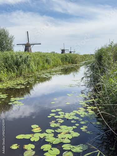 Historische Windmühlen an ruhigem Wasserkanal