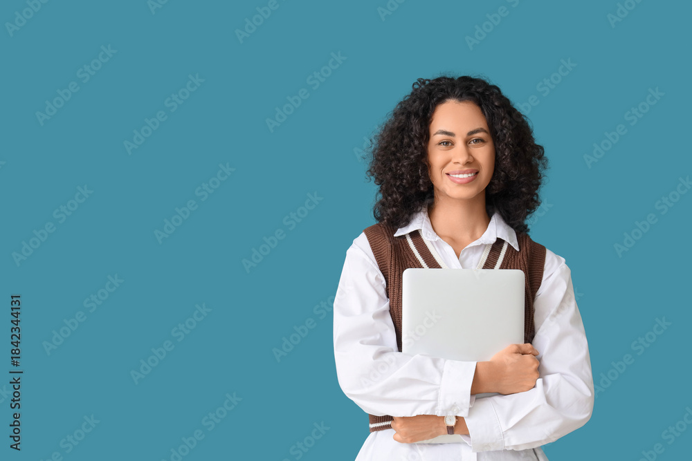 Obraz premium Young African-American businesswoman with laptop on blue background