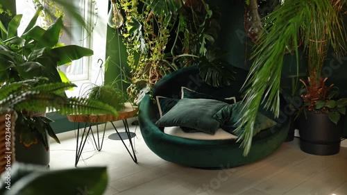 Cozy eco living room interior in loft style with houseplants in pots, armchair and pillows for relax. Interior modern design at home. Many pots with green plants placed near armchair in dark room
