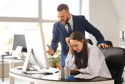 Angry male boss shouting at...