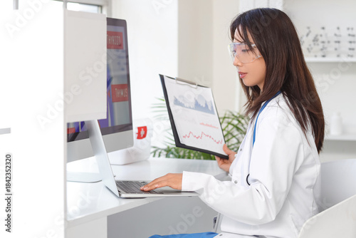 Female Asian doctor with la...