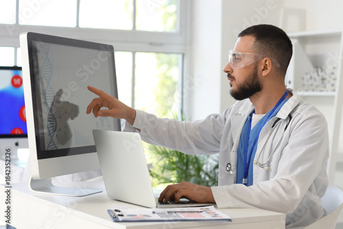 Male doctor analyzing scientific data at desk in laboratory