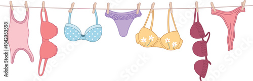 Assorted laundry items hanging on a clothesline with wooden pegs washing drying