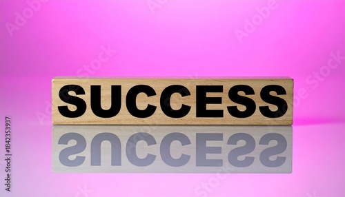 Wooden block labeled “SUCCESS” with reflection on pink-purple gradient background.