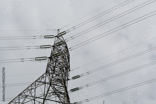 Electricity pylon distributing power lines against cloudy sky