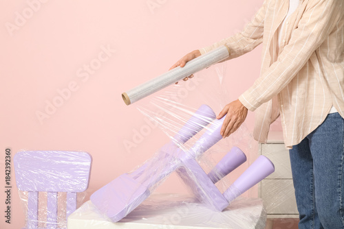 Young woman wrapping chair ...