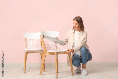 Young woman wrapping chair ...