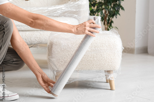 Young woman wrapping pouf w...