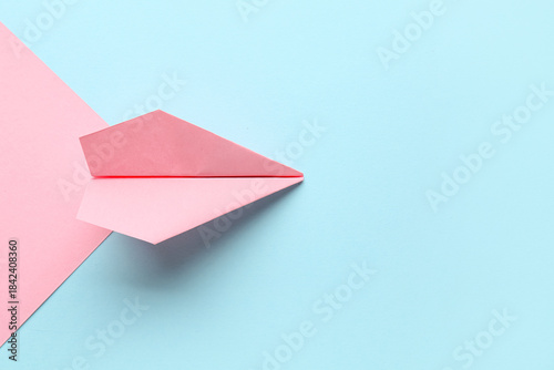 Pink paper plane on color b...