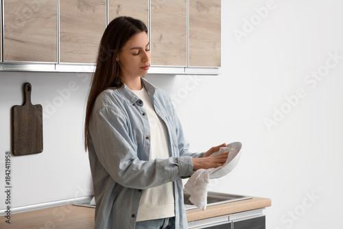 Young woman wiping ceramic ...