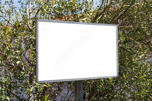 Close-up of small billboard with empty mockup in the woods.