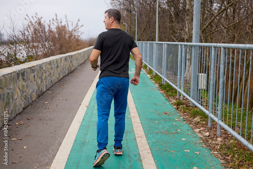 A middle-aged man does morning warm-up exercises and runs.