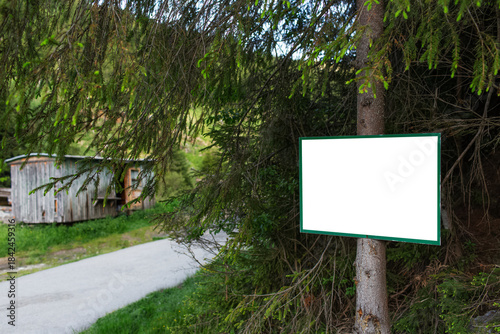 Close-up of small billboard with empty mockup in the woods.