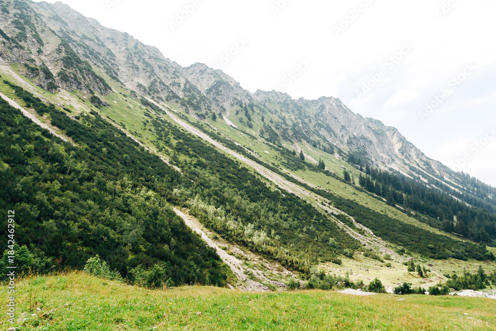 Obraz premium Panoramic View of High Mountains During a Summer Hike, Sunny Alpine Landscape and Outdoor Adventure Concept