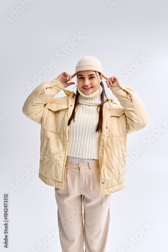Trendy teenage girl styled in cozy winter fashion in a bright studio setting
