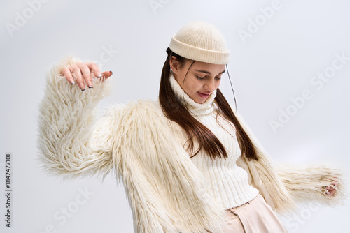 Bild auf Leinwand Trendy winter fashion: a stylish girl in a faux fur jacket in a bright studio