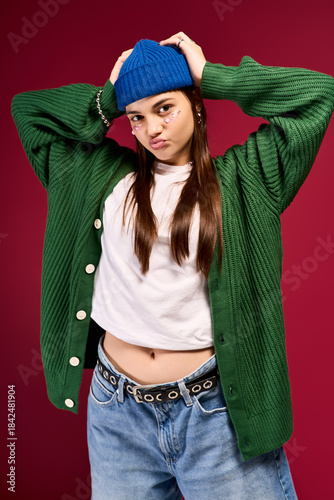 Trendy teenage girl showcases winter style with vibrant colors in a studio setting