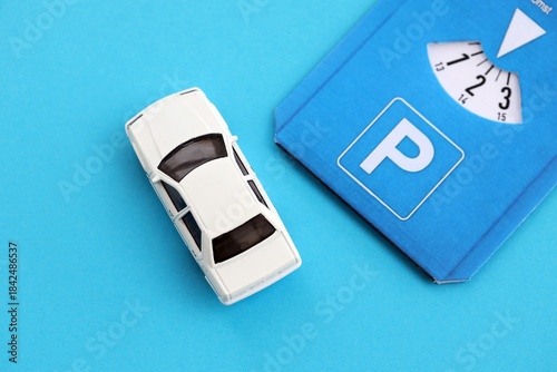 Parking disc for windshield and white toy car. Limited time parking system in european countries. Concept of parking time count in busy parking lots