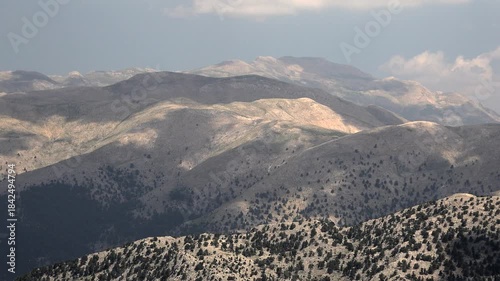Aerial view of treeless rocky slopes across the Zagros Mountains in Iran. Vast barren highlands reveal raw stony textures and arid mountain geology.
