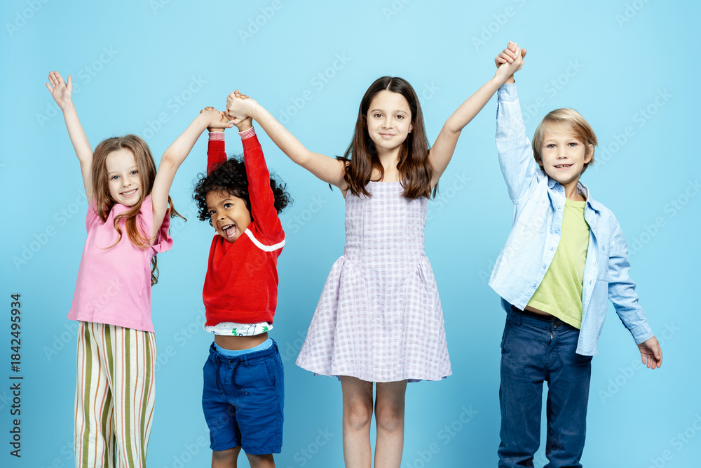 Fototapeta premium Diverse children friends holding hands forming a team on a blue background