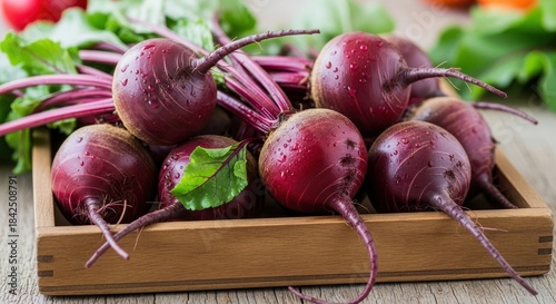 Freshly harvested beets with vibrant greens, resting in a rustic wooden crate