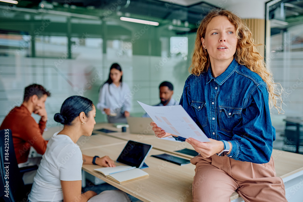 Obraz premium Thoughtful business woman holding charts during a meeting, visualizing future plans and analyzing data for corporate growth