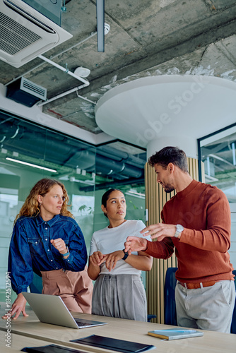 Принти на полотні Three diverse business people collaborating, sharing ideas, and planning strateg