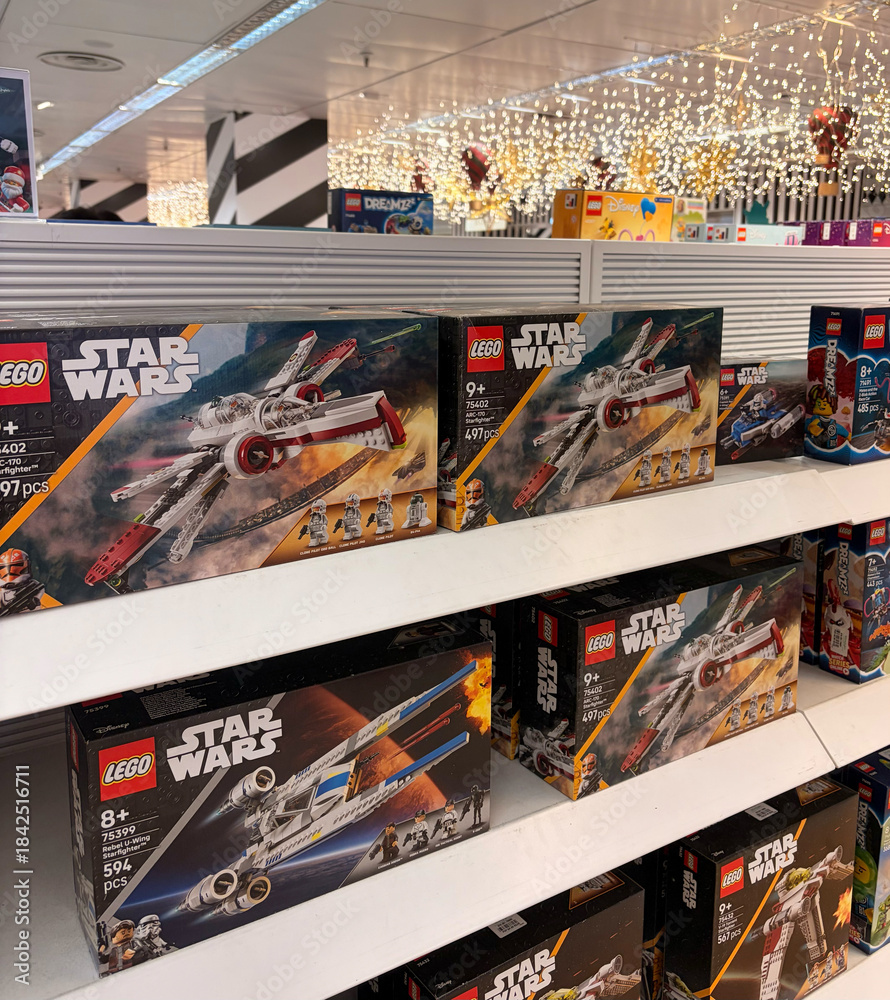 Obraz premium Alicante, Spain - December 11, 2025: LEGO Star Wars building sets displayed on shelves in a toy store, showcasing various models and vibrant packaging for fans of all ages