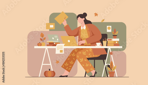 Businesswoman working remotely at a cozy autumn desk with a laptop and seasonal decorations