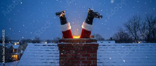 Santa stuck in chimney feet first on snowy rooftop during evening snowfall