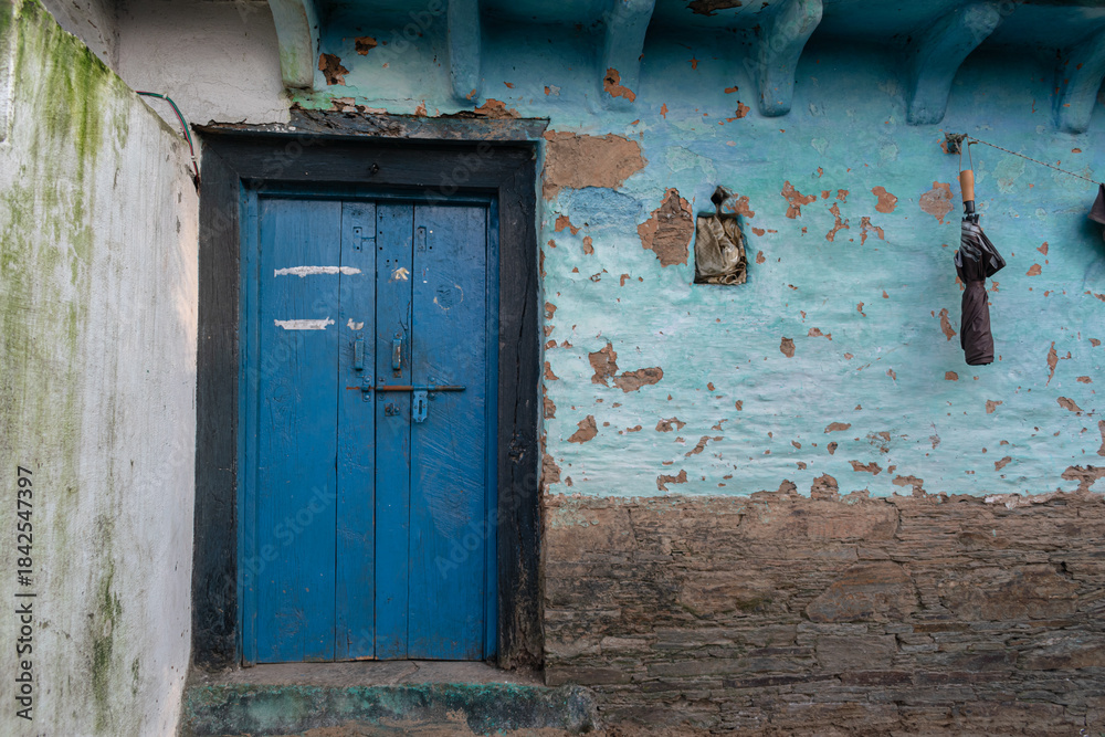 Naklejka premium A village house made of mud and stone with wooden doors.