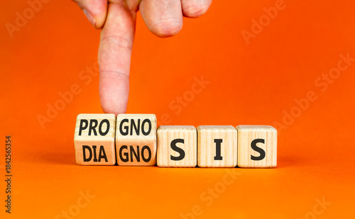 Prognosis or diagnosis symbol. Concept words Prognosis or Diagnosis on beautiful wooden blocks. Beautiful orange background. Doctor's hand. Business prognosis or diagnosis concept. Copy space.