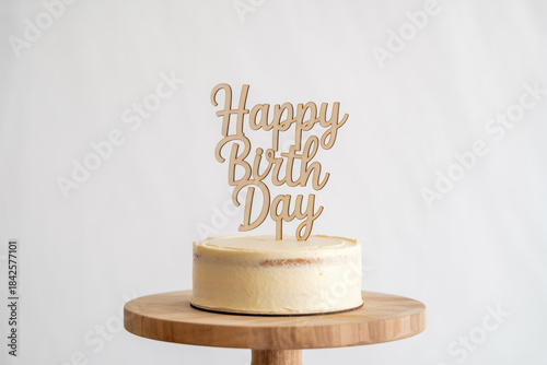 Delicious semi-naked birthday cake with Happy Birthday wooden sign on wooden cake stand