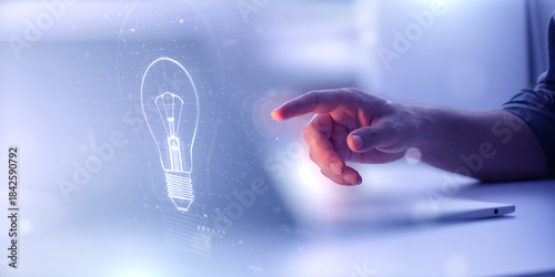 Fotografie A hand reaches toward a glowing digital lightbulb hologram icon
