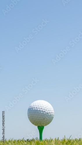 Perfect Golf Setup: White Ball on Green Tee Against Blue Sky - Sports Ecommerce Concept