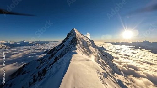 Majestic mountain peak bathed in golden sunlight above a sea of clouds