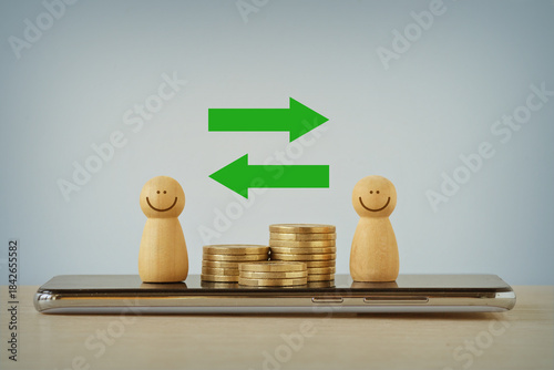 Wooden pawns and piles of coins with arrows on mobile phone - Concept of money transaction and exchange