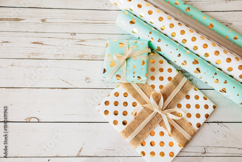 Wallpaper Mural Stylish gift wrapping scene with golden dotted and heart pattern paper, ribbons and bows. Flat lay on vintage wood, perfect for seasonal marketing and craft projects Torontodigital.ca
