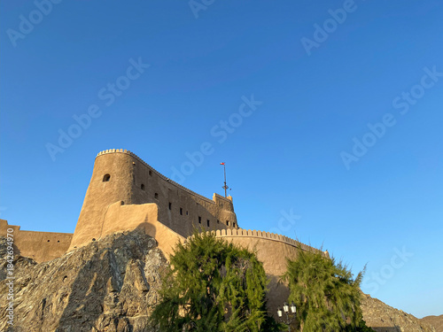 Obraz na płótnie Majestic ancient fort perched high on rugged rocks under a clear blue sky in Mutrah Fort, Muscat, Oman