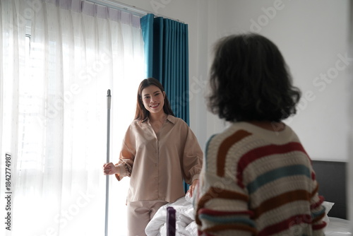 Wallpaper Mural Caregiver helping elderly woman making bed at home Torontodigital.ca