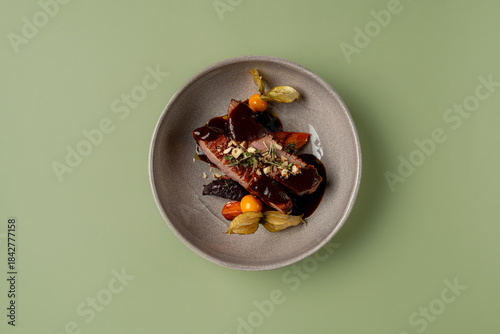 Valokuva A beautifully arranged plate features succulent meat drizzled with rich sauce, s
