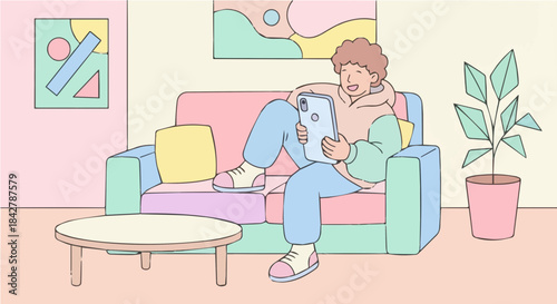 A cheerful person with curly hair relaxing on a pastel-colored sofa, looking at a tablet in a cozy living room with abstract art and a plant.