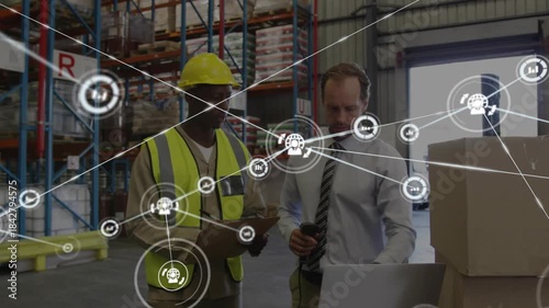 Warehouse manager tapping scanner while worker checking inventory, data network overlaying scene